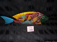 Right side view of multicolor wooden fish sculpture against black background