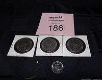 Three 1971 dollar coins in flips and one 1967 nickel displayed