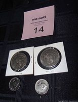 Front view of two 1971 dollars in flips and two loose 1967 nickels