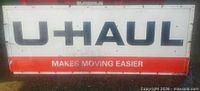 Front view of U-Haul sign showing logo, slogan, colors, wear