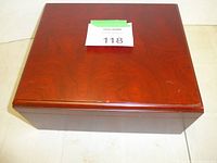 Closed mahogany humidor top view, reddish-brown wood grain visible