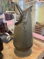 Full left side view of brass coal scuttle