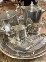 Coffee pot, teapot, creamer, tray and sugar tongs pictured together