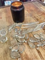 Mixed chandelier crystals spread on wooden surface; teardrops and prisms visible