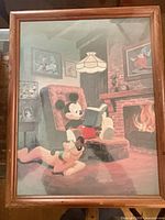 Full view of framed Disney print showing Mickey Mouse reading with Pluto, wood frame visible