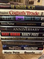 Stack of all ten hardcover novels showing spines and titles