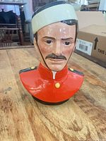 Front view of porcelain RCMP bust figurine showing red tunic and facial details