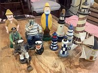 Group view of all nautical figurines, lighthouses and sailboat on table