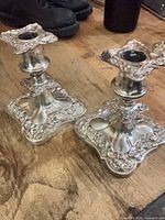 Two ornate silver-plated candlesticks