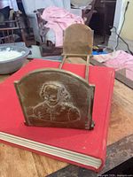 Overall view of brass expandable book rack on red book