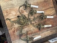 Full view of five-arm brass wall sconce on wood surface