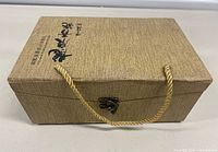 Closed textured box with rope handle and printed Chinese characters
