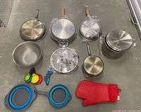 Entire lot laid out showing cookware, accessories and condition.