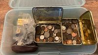 Overview of tote showing coins, tins, coin purse, bags, novelty bar
