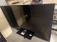 Front view of 80-inch Sharp TV with stand