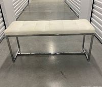 Front view of cream faux leather bench on chrome base