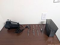 Mixer, four attachments and storage cup on tabletop