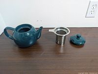 Teapot body, stainless infuser, lid displayed side by side