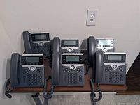 Front view of all six Cisco CP-7841 phones grouped on table