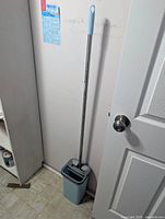 Mop and bucket set leaning against wall