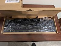 keyboard in box showing wrapped unit and USB Type-A cable