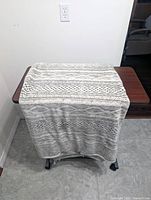 Throw blanket draped over table showing full front pattern