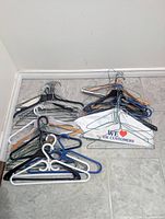 Pile of mixed wire, plastic and wood hangers on floor