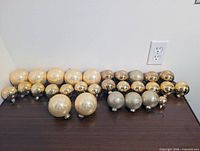 Front view of all 29 gold ornaments showing size variation and finishes