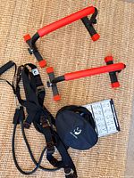 Parallette bars, resistance strap set, pouch and guide laid out on mat