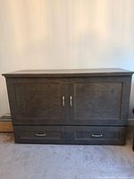 Front view of closed cabinet bed showing doors and drawer