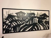 Full view of framed abstract cityscape painting on wall