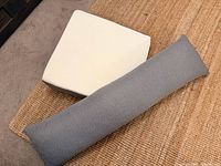 Grey Orthex body pillow beside white memory foam wedge pillow