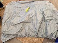 Full view of silver-gray motorcycle cover displayed, elastic bottom visible
