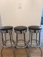 Three chrome bar stools front view