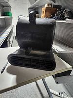 Side view showing rectangular outlet vent and overall housing