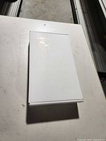 Plain white sealed box containing ADT touchscreen control panel on tabletop