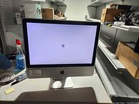 Front view of Apple iMac9,1 showing powered-on startup screen