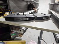 Two Bose Wave CD changer attachments on table