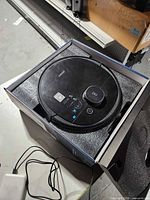 Black Ecovacs Deebot robot vacuum in box with foam insert