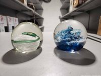 Front view of both glass paperweights side by side