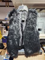 Front view of black faux fur vest on hanger
