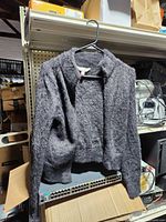 Front view of gray fuzzy cardigan on hanger