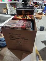 Box with visible DVD titles Charlie Chan, Burlesque, Star Wars Trilogy and other cases