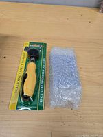 Carded yellow safety handle and bubble-wrapped punch set on table