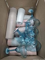 Top-down view of box showing ribbed pastel tumblers and blue stemmed glasses