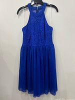 Front view of royal blue lace cocktail dress on hanger