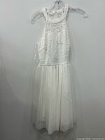Front view of ivory lace cocktail dress on hanger