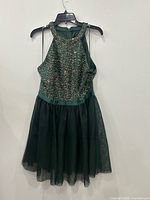 Front view of green sequin halter dress on hanger
