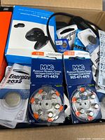 Overview of box contents including earbuds box, hearing-aid batteries, CR2032 pack, cables