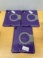 Three sealed purple cases front view